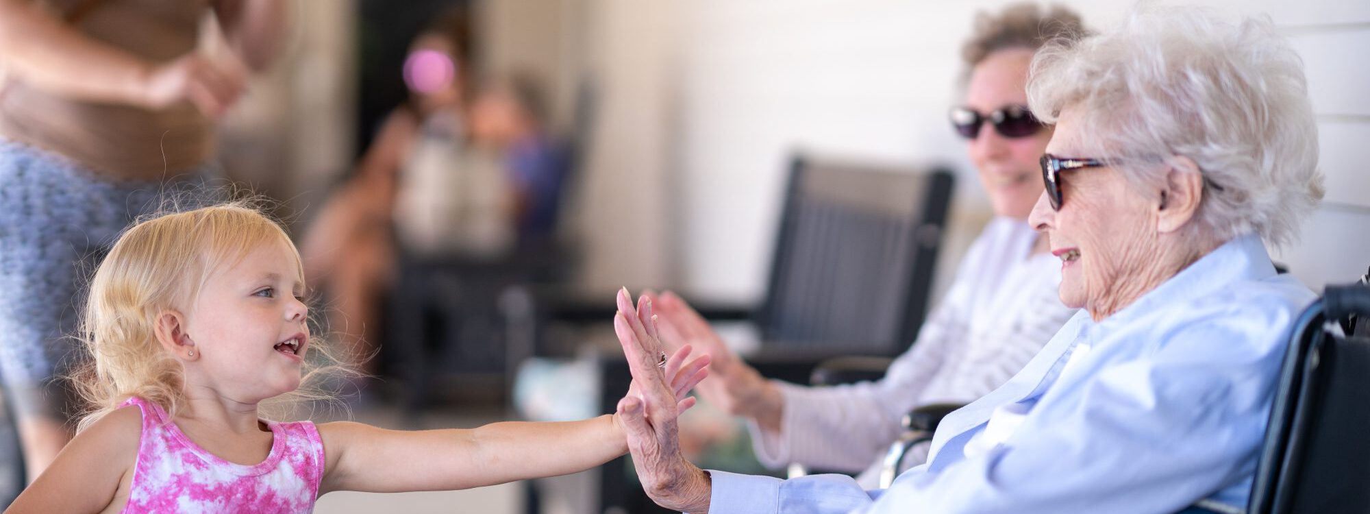 A child giving a high-five to a resident at Lutheran Life Villages