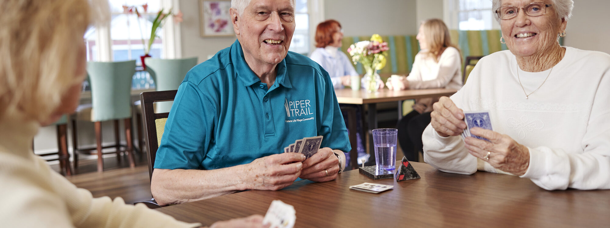 cards a group of lutheran life village residents playing a game of cards